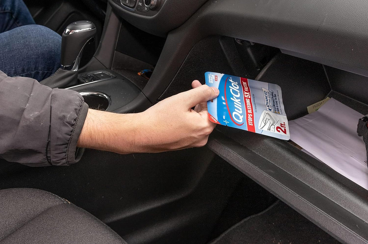 Person placing a QuikClot product in a car's cup holder.