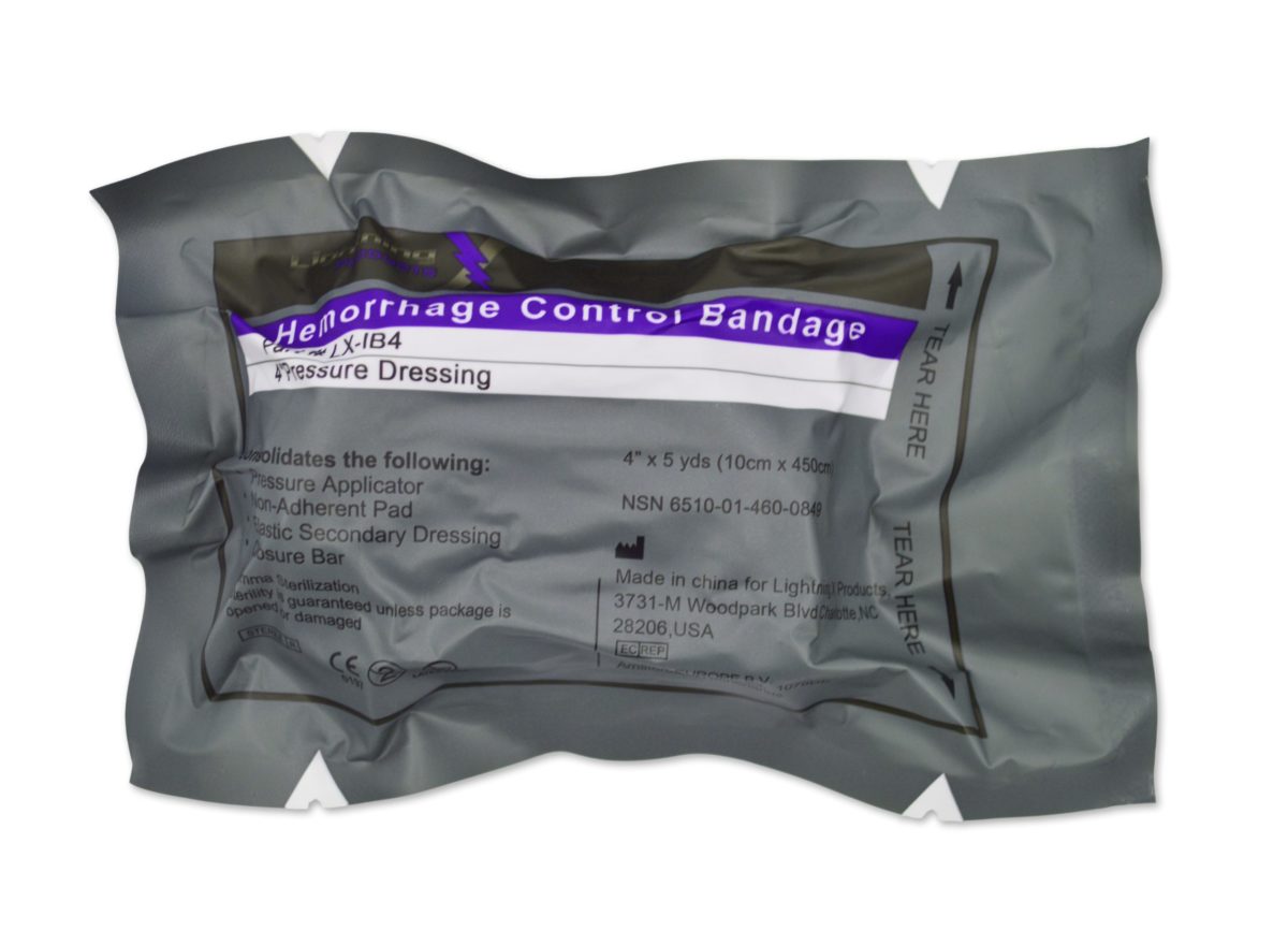 A vacuum-sealed package of a hemorrhage control bandage, labeled as a pressure dressing, with usage instructions and product information visible on the label.