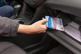 Person placing a QuikClot product in a car's cup holder.