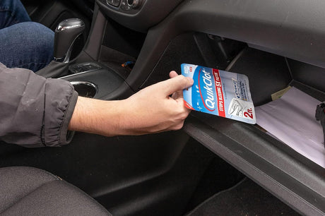 Person placing a QuikClot product in a car's cup holder.