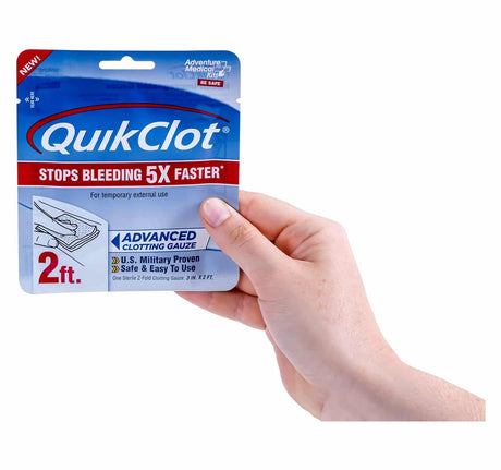 QuikClot packaging held by a hand on a white background