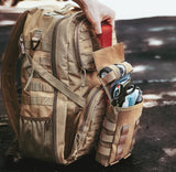 Fully stocked tan tactical IFAK pouch attached to MOLLE backpack, displaying trauma shears, QuikClot gauze, and emergency medical gear ready for rapid deployment.